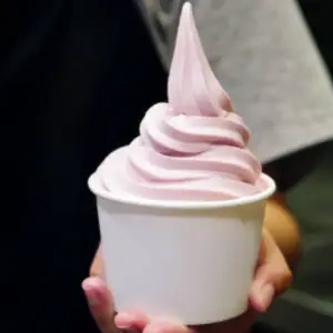 A hand reaching for a container of ice cream during a frozen yogurt event at work