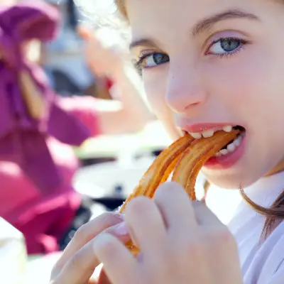 A girl eating churros during a churros bar event at work