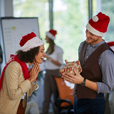 personnes qui s'offrent des cadeaux durant une animation arbre de noël en entreprise